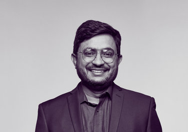 Dr Sabar, an oncologist, wearing a suit and smiling at the camera